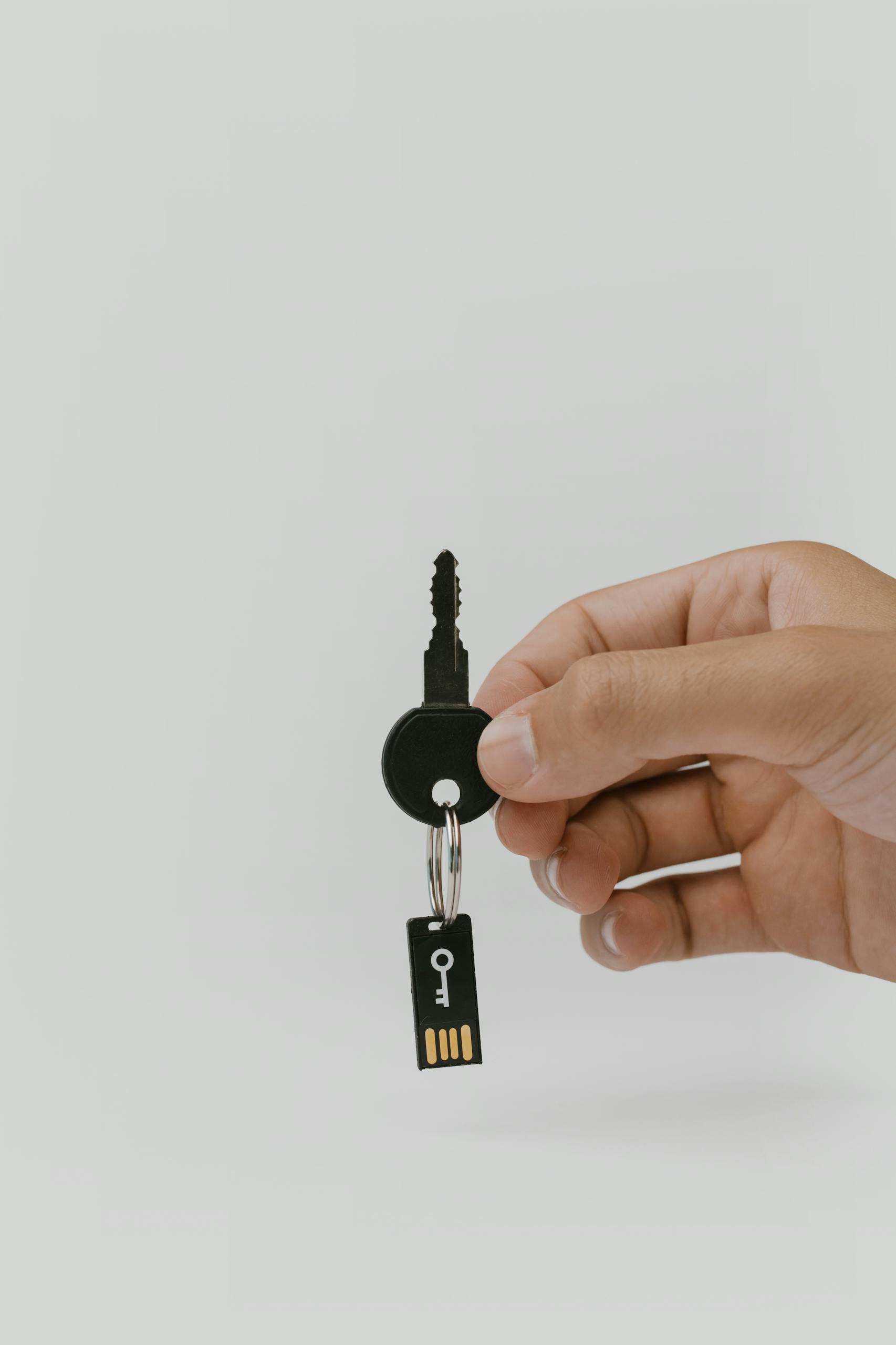 Close-up of a hand holding a key and USB with copyspace.